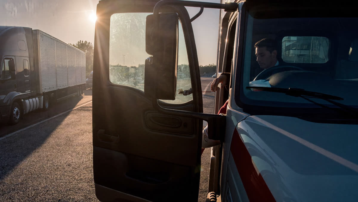 AI-generated photo: a driver climbing into a semi truck cab at dawn