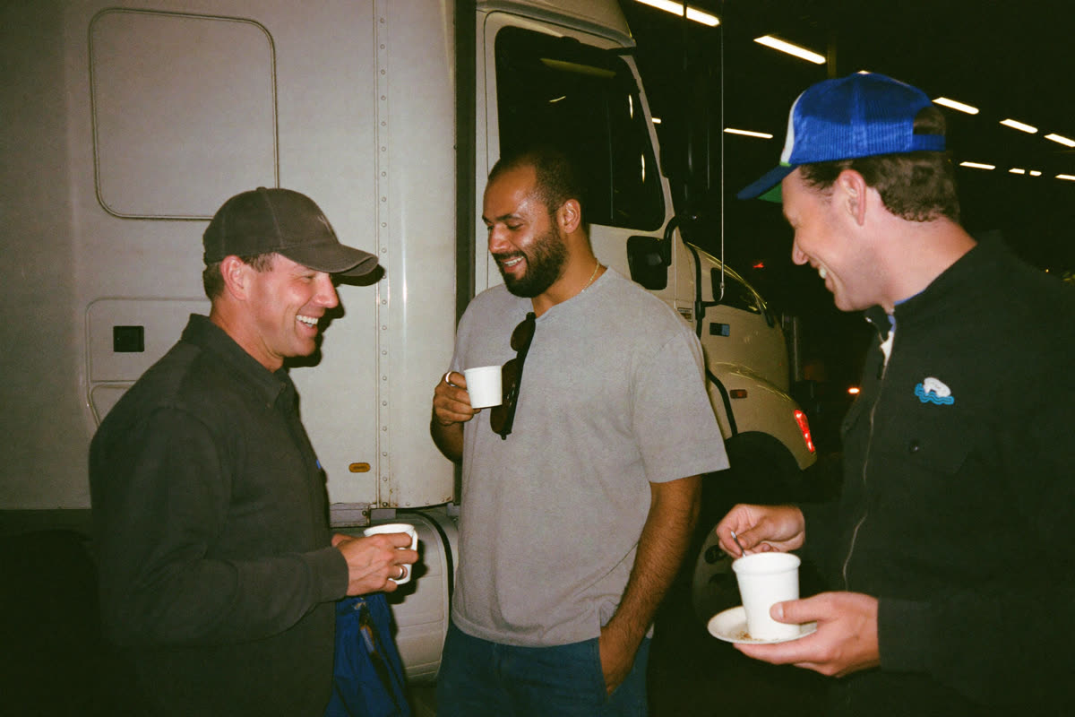 AI-generated photo: truck drivers sharing coffee next to their truck at night