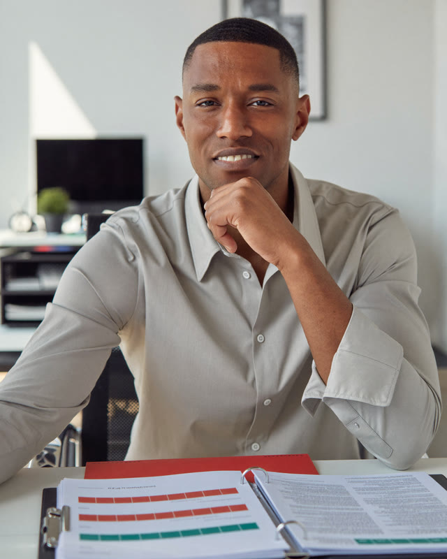 AI-generated portrait: safety manager at his desk with a compliance binder